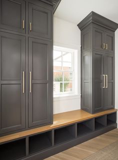 an empty room with gray cabinets and wood flooring