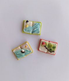 three miniature pieces of food on a white surface