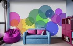 a living room with a blue couch and colorful balloons painted on the wall behind it