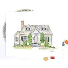 a watercolor painting of a house on a plate