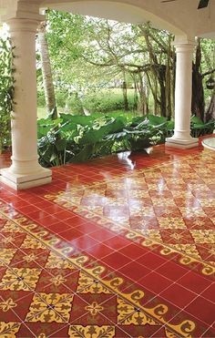 a red and yellow tiled patio with columns