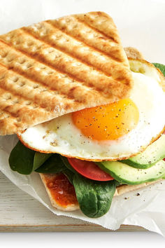 a sandwich with an egg, tomato and cucumber on it