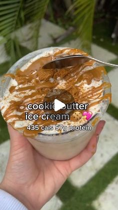 someone is holding up a bowl of ice cream with caramel and cookies on top