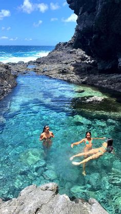 two people are swimming in the clear blue water