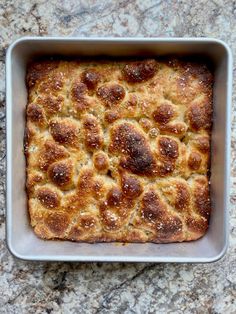 a square casserole in a metal pan on a granite counter top, with meatball toppings