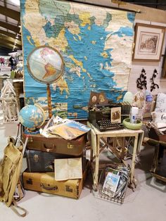 an old world map is on the wall next to many suitcases and other items