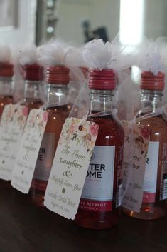 several bottles of liquor are lined up on a table with tags attached to the bottles