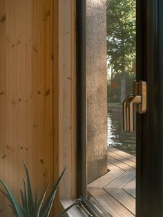 a plant is sitting in front of the door to a house with wooden floors and walls