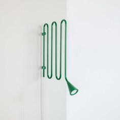 a wall mounted rack with three green utensils