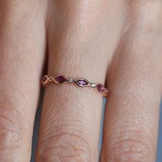 a woman's hand with a pink diamond ring on top of her left finger