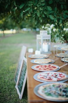 an outdoor table with plates and candles on it