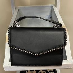 Introducing the Studded Purse, a chic fusion of edgy style and practical sophistication. This black purse is adorned with a bold stud-lined pattern, adding a touch of rock-inspired flair to your ensemble. Crafted with both fashion and functionality in mind, the Studded Purse features a convenient long strap for versatile wear – effortlessly transitioning from a stylish crossbody to an elegant shoulder bag. The sleek black color ensures easy pairing with a range of outfits, while the studs provide a bold statement for those who appreciate a touch of rebellion in their accessories. Studded Purse, Edgy Style, Black Purse, Of Outfits, Black Purses, Edgy Fashion, Front Porch, Alabama, Black Color