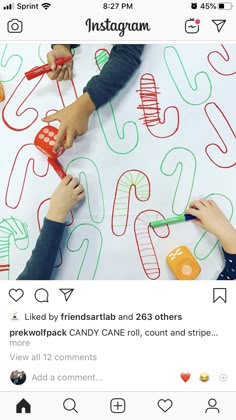 two children are drawing letters on a sheet of paper with crayons and markers