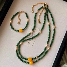 This double-strand necklace is an eye-catching blend of elegance and boldness, featuring green jade beads with golden accents, complemented by striking yellow gemstone spheres and freshwater pearls. The high-quality gold-plated brass ensures durability while enhancing the luxurious appearance. Ideal for both formal and casual occasions, this necklace is sure to elevate any outfit with its rich colors and refined design. Details Material: 24K gold-plated brass, green jade, freshwater pearls, and Chrysoprase Necklace, Double Strand Necklace, Green Chalcedony, Yellow Gemstones, Stone Beaded Necklace, Natural Stones Necklace, Pearl Jewelry Necklace, Gold Statement Earrings, Natural Stone Jewelry