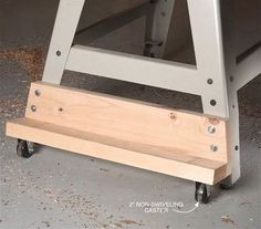 a metal and wood step stool sitting on top of a cement floor next to a wall