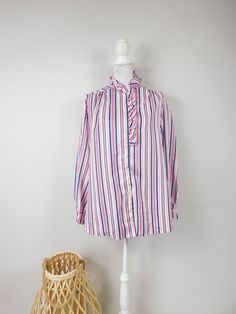 "Vintage 80s Pink Blue White Vertical Striped Print Ruffled Collared Button Up Shirt Long Sleeve Top Blouse Xl Plus Size This top is used but in good condition with no odors, tears, staining or repairs. Very light material. Added shoulder pads. Appropriate for any casual, or evening occasion. This top measures: Bust: 46\" Waist: 48\" Hips: 48\" Top to Bottom: 30\" Sleeve: 27\" (Measurements are taken across item laying flat and are then doubled.) Thanks for looking! Domestic Shipping: First Clas Pink Button-up Blouse With Ruffles, Pink Ruffled Button-up Blouse, Retro Long Sleeve Ruffled Tops, Retro Ruffled Long Sleeve Tops, Retro Pink Blouse With Buttons, Vintage Blouse With Ruffled Collar And Button Closure, Vintage Blue Ruffled Blouse, Vintage Button-up Ruffled Tops, Vintage Button-up Ruffled Blouse