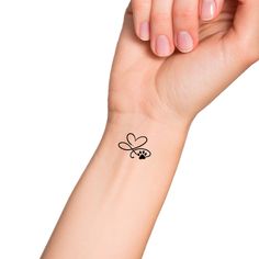 a woman's arm with a small bee tattoo on the left side of her wrist