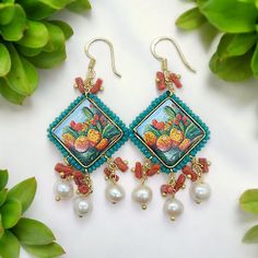 Sicilian tile earrings with  pearl and coral. The tile is in Caltagirone ceramic and is hand painted, it depicts the prickly pear, a typical plant of the Sicilian lands, it is made on majolica lava stone. The pendants are freshwater pearls and natural coral branch, of various shapes and sizes. The hook is in gold-plated silver. The tile measures 3x3 cm  ( 1,18x1,18 Inch) Total length 6,5cm. (2,55 Inch) Unique, original and very light! All the materials used are of the highest quality and hypoall Handmade Mediterranean Jewelry For Gift, Tile Earrings, Ceramic Earrings, Ceramic Earring, Natural Coral, Prickly Pear, Lava Stone, Gold Plated Silver, Sicily