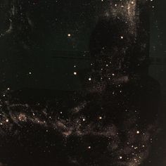 a black and white photo with stars in the sky on it's side as seen through a window