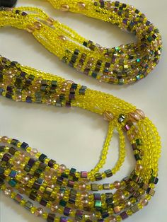 Double Strand Waist Bead, featuring vibrant yellow crystal glass beads with striking square purple AB crystal accents. Why You'll Love It: Vibrant Sparkle: Gorgeous yellow crystal glass beads radiate a lively, eye-catching brilliance. Unique Accents: Square purple AB crystal beads add a distinctive and luxurious touch. Perfect Fit: The adjustable double strand design ensures a comfortable and secure fit for all body types. Cultural Elegance: This piece captures the rich heritage of Ivorian craftsmanship, blending traditional beauty with contemporary style. Color Significance: Yellow: In Ivorian culture, yellow symbolizes happiness, energy, and vitality. Wearing yellow beads can uplift your spirit and evoke a sense of joy and warmth. Purple: Purple represents royalty, wisdom, and spirituali Elegant Gold Waist Beads With Colorful Details, Bohemian Multi-strand Waist Beads With Colorful Beads, Bohemian Multi-strand Colorful Waist Beads, Multicolor Polished Waist Beads, Gold Multi-strand Beaded Waist Beads, Body Types, Crystal Beads, Contemporary Style, Perfect Fit