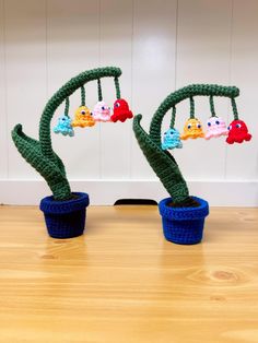 two crocheted planters sitting on top of a wooden table