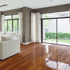 a living room with hard wood flooring and large sliding glass doors leading to the backyard