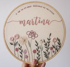 someone is holding up a embroidery kit with flowers and the words martina on it