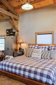 a bed sitting in a bedroom next to a wooden dresser and table with two lamps on top of it