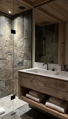 a bathroom with two sinks and a walk in shower next to a large mirror on the wall