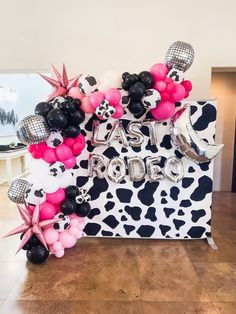 the balloon arch is decorated with black, white and pink balloons