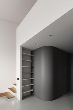 an empty room with some shelves and stairs