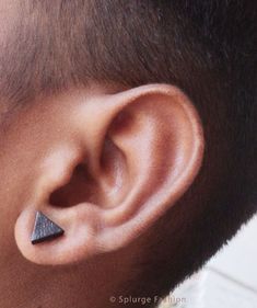 a close up of a man's ear with a black triangle on it,