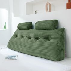 a bed that has some pillows on top of it in a room with white walls