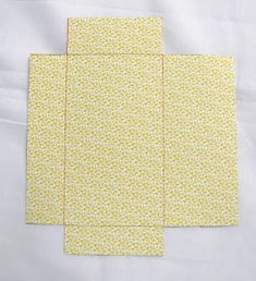 four pieces of yellow patterned paper on top of each other