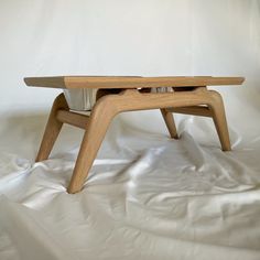 a wooden table sitting on top of a white sheet