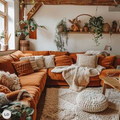 a living room filled with lots of furniture and plants on top of the couches