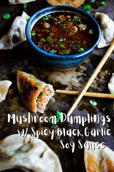 mushroom dumplings with spicy black garlic soy sauce in a blue bowl and chopsticks