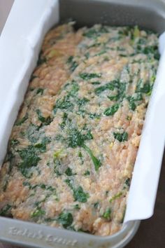 a casserole dish with spinach and cheese in it sitting on a table