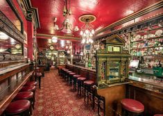 an old fashioned bar with red leather stools