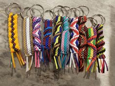 several key chains are lined up together on the floor with different colors and designs attached to them