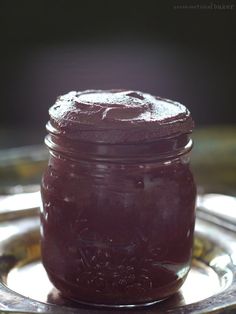 a glass jar filled with purple liquid on top of a metal tray