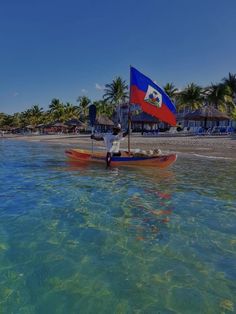 a man in a boat with a flag on the beach