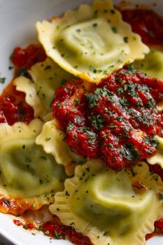 some ravioli with sauce and parsley in a white bowl