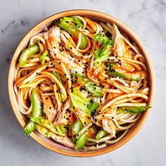 a bowl filled with noodles and vegetables on top of a table