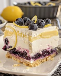 a piece of cake with blueberries and lemons on it sitting on a plate