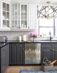 a kitchen with white cabinets and gray counter tops, along with an area rug on the floor