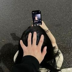 a person is holding up their cell phone to take a selfie with her hair