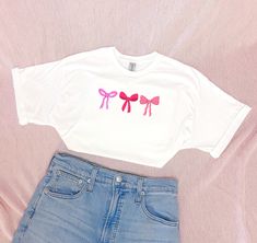 The cutest hand-crafted pink bow t-shirt, perfect to make you feel so cute this Valentine's day!  Welcome to ThreadedJoyCompany! My husband and I are a small business hoping to cultivate joy in people through our hand-drawn, original designs and trendy handmade apparel. Thank you so much for supporting us! Wear Joy, it looks good on you! ✧ Details: ▸T-shirt color: White and Pink  ▸T-shirt Material: 50% Cotton/50% Polyester ▸Sizes: Unisex S, M, L, XL, XXL     (see size guides in photos) ✧ Washing: ▸ Wash inside out with similar colors in warm water. ▸ Use non-chlorine bleach and tumble dry on low heat. ▸ Do not iron or dry clean. ✧ Returns & Exchanges: ▸ Our products are made to order, so returns and exchanges are not accepted; however, if you change your mind immediately after placing an o Valentine Bows, Valentine Shirt, Valentine T Shirts, Pink Tshirt, Valentines Shirt, Shirt For Women, Cute Bows, Handmade Clothes, Pink Bow