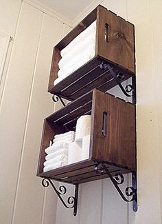 two wooden boxes are stacked on top of each other with white towels in the bottom