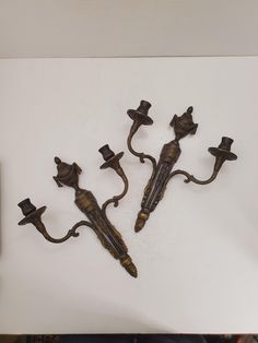 three metal wall sconces with hats on them